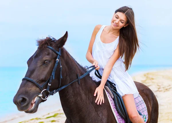 Gyönyörű lány, hosszú szőke haj, barna ló a a parton az Indiai-óceán a sziget Mauritius lovaglás — Stock Fotó