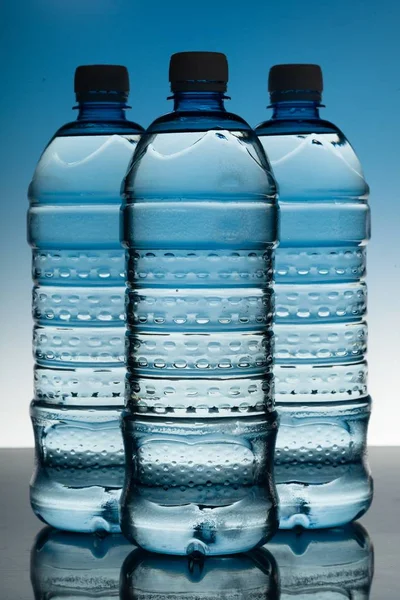 Tres botellas de agua en el Bakcground Azul — Foto de Stock