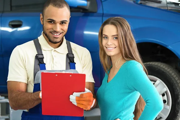 自動車整備士と自動車修理店に笑みを浮かべて顧客 — ストック写真