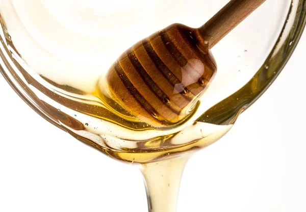 Nalévá med s naběračka medu — Stock fotografie