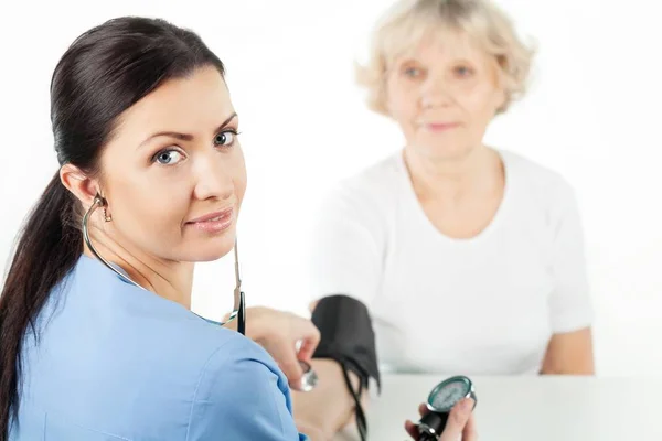 Profesional médico que toma la presión arterial de un adulto mayor —  Fotos de Stock