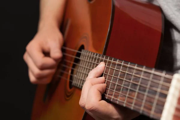 Человек, играющий на акустической гитаре, закрытый, изолированный — стоковое фото