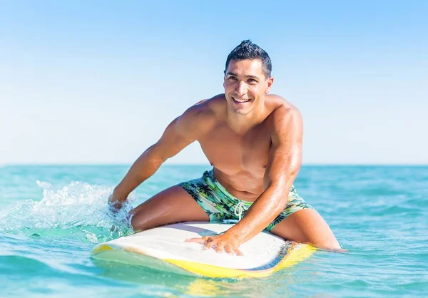 Man swimming over surfboard in the water.