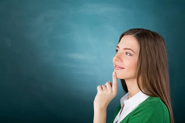 Kvinnelig student som tenker mot Chalkboard – stockfoto