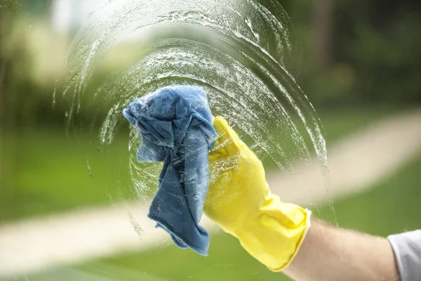 Gloved hand cleaning window — Stock Photo, Image