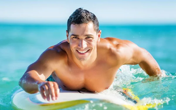 Smiling Masculino Boarding Surfboard em águas profundas — Fotografia de Stock