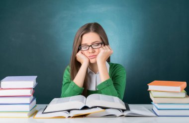 Sınıf ders kitapları ile sıkılmış kız öğrenci