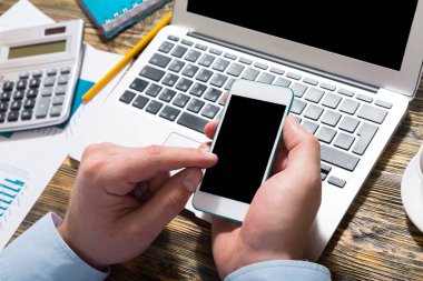 Modern laptop klavye yazarak ve smartphone kullanarak eller