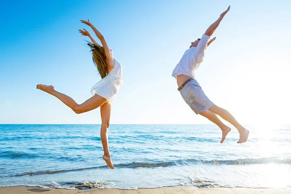 Springen vakantie paar op strand — Stockfoto