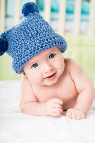 Bambino bambino sdraiato sulla pancia indossando un cappello giullare — Foto Stock