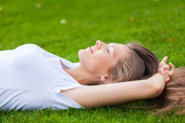 Retrato de uma jovem mulher dormindo em um parque — Fotografia de Stock