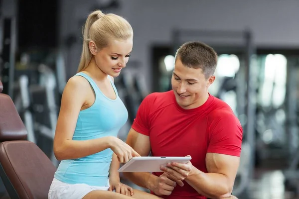 Mujer con su entrenador personal de fitness en el gimnasio haciendo ejercicio con pesas —  Fotos de Stock