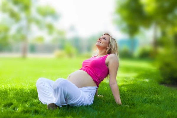 Retrato de uma mulher grávida em um parque — Fotografia de Stock