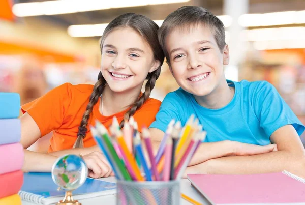 Niños sentados junto a la mesa durante la lección — Foto de Stock