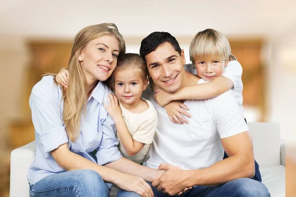 Happy family of four smiling at camera