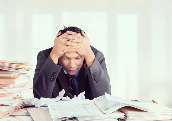 Businessman near heap of papers — Stock Photo, Image