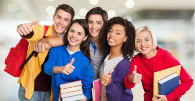 Başparmakları gösteren gülümseyen bir grup öğrenci