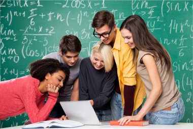 Dizüstü bilgisayar ve kitap okuyan genç öğrenciler  