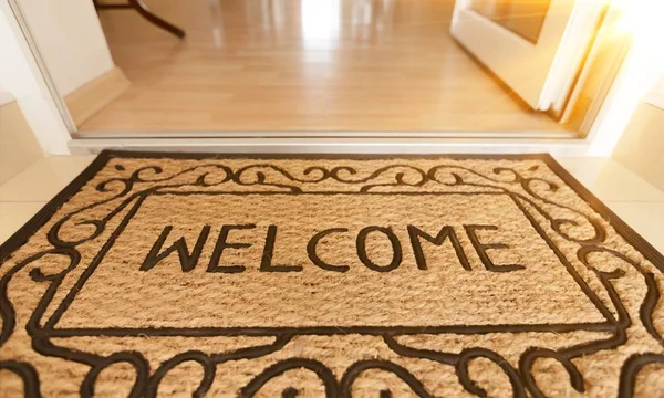 new welcome doormat on wooden floor