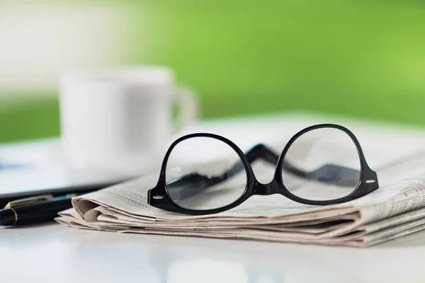 Stack of newspapers and eyeglasses — Stock Photo, Image