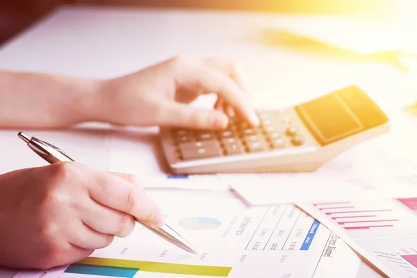 Financial data analyzing. Close-up photo of a businessman working with calculator in office. Selective focus