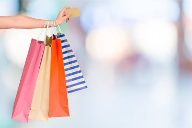 Alışveriş çantaları ve kredi kartı olan genç bir kadın. 