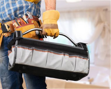 Genç adam işçi alet kemeri ve kask ile