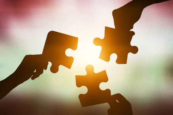 Hands joining puzzle parts, business concept
