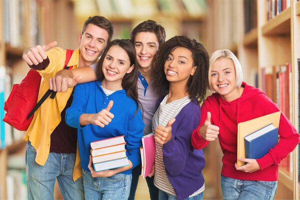 Group of Students with books smiling at camera