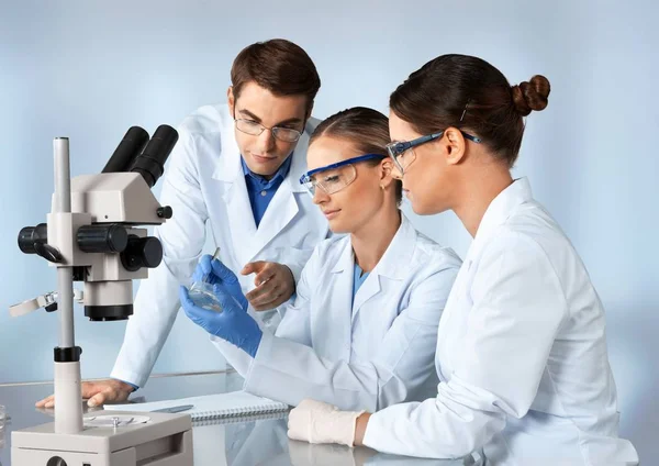 戴眼镜的男女科学家在显微镜下工作 — 图库照片