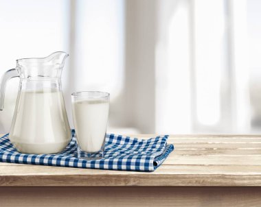 Bardak süt ve sürahi masada 