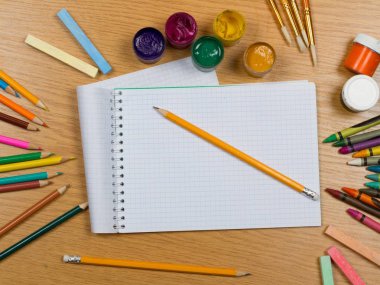 Not defteri ve okul malzemeleri ahşap arka plan üzerinde