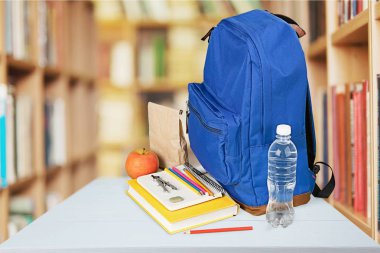 Ahşap masa üzerinde okul sırt çantası ile ileti örneği