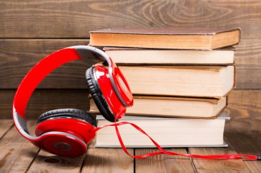 Kitaplar ve ahşap masa kulaklıktan yığını