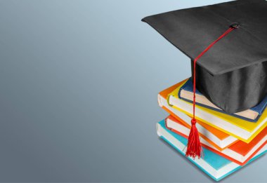 Mezuniyet şapka ve kitap yığını 