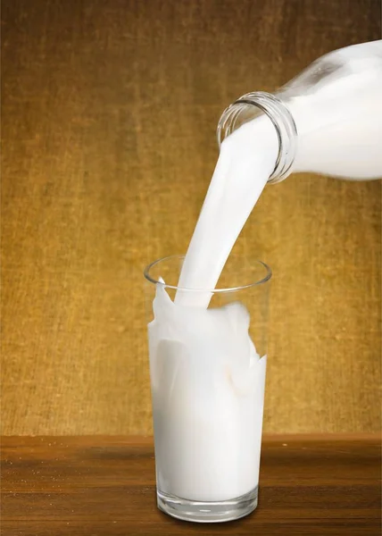 Milch in Glas gießen — Stockfoto