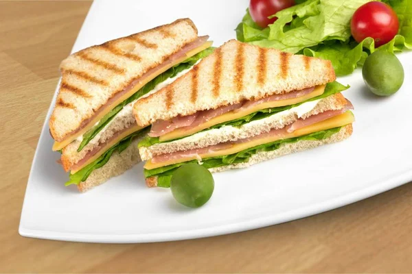 Izgara sandviç beyaz tabakta yarısı