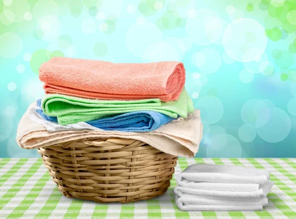 Haufen Flauschige Handtücher Und Weidenkorb — Stockfoto