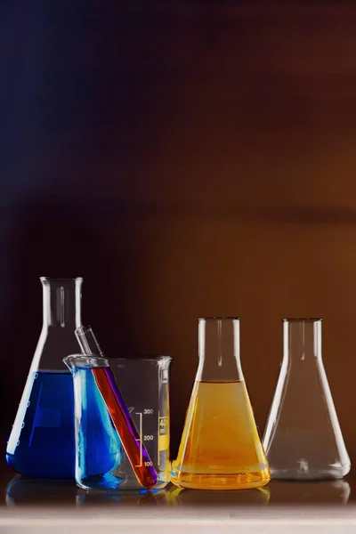 Glass laboratory flasks on light background