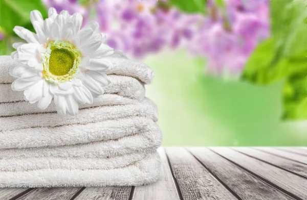 Haufen Flauschige Handtücher Und Schöne Blumen — Stockfoto