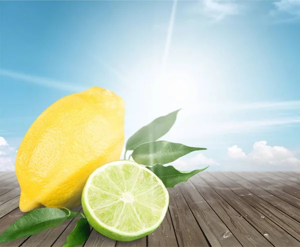 木製のテーブル 柑橘系の果物のライムとレモンをスライス — ストック写真