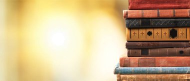 Eski kitaplar bulanık arka plan üzerinde yığılmış 