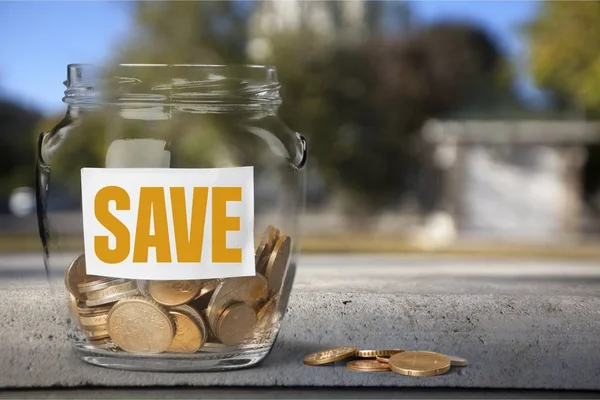 Money Jar with coins on wooden table