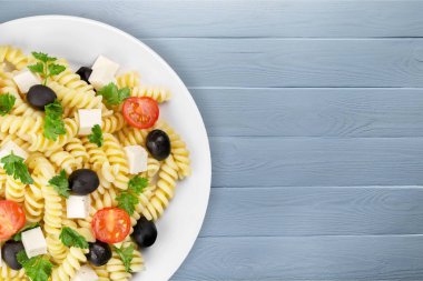 İtalyan makarna domates, zeytin ve ahşap zemin üzerine peynir ile