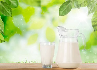 Bardak süt ve sürahi masada 