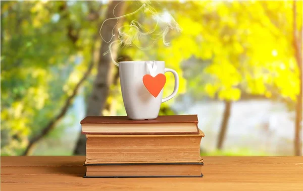 Pile of books with tea cup on table