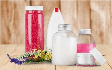 Açık renkli sıvı kozmetik şişeleri çiçeklerle