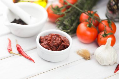 Lezzetli domates sosu ile baharat tablo arka plan üzerinde tabak