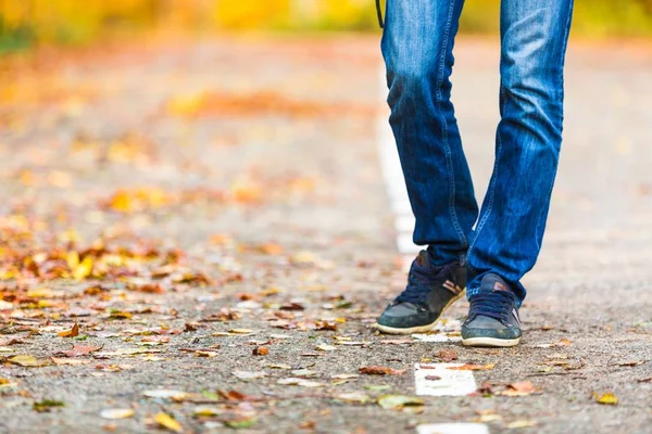 closeup of male legs during autumn walk in park