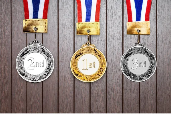 Gold, silver and bronze medals on wooden background